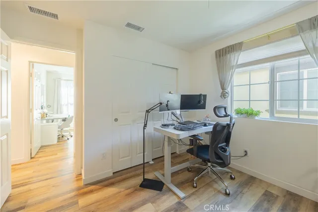 a view of a workspace with furniture and a window