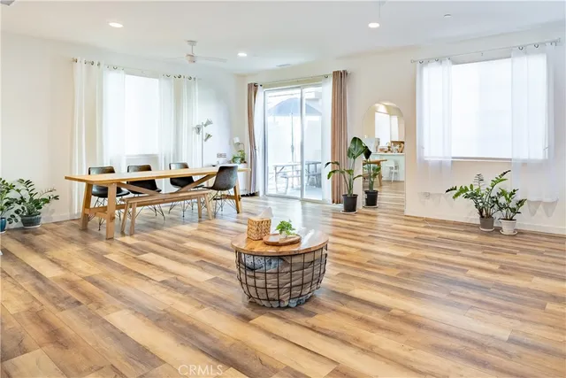 a living room with furniture a wooden floor and a potted plant