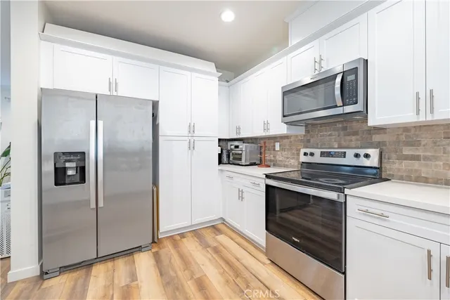 a kitchen with stainless steel appliances granite countertop a refrigerator stove and microwave