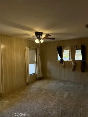 an empty room with closet and chandelier fan