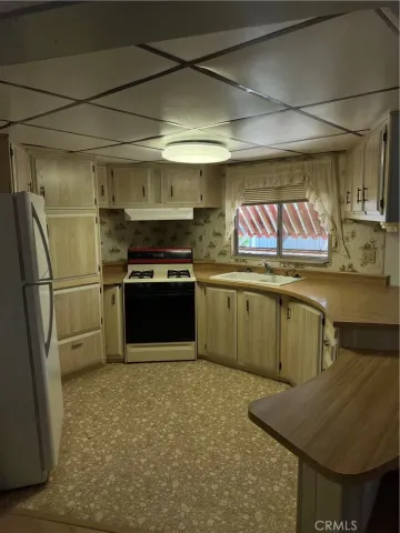 a kitchen with stainless steel appliances granite countertop a sink a stove and a refrigerator