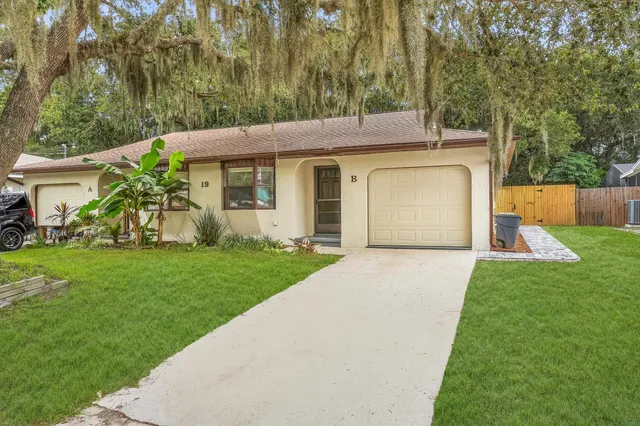 a view of a house with a yard and potted plants