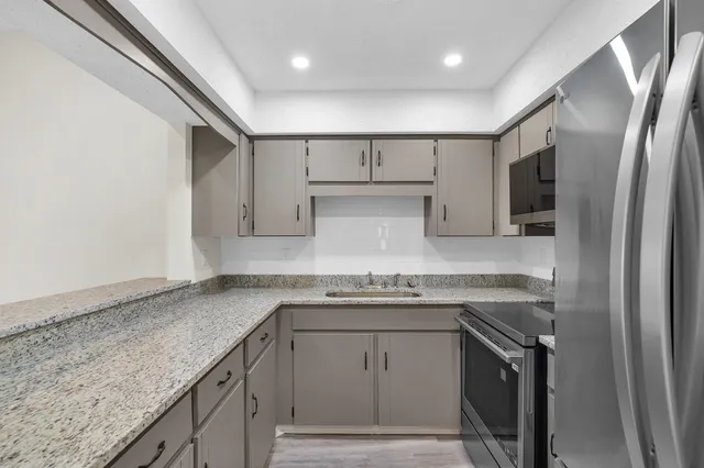 a kitchen with stainless steel appliances granite countertop a sink stove and refrigerator