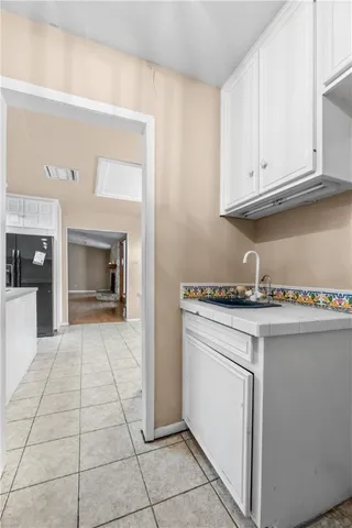 a kitchen with stainless steel appliances a refrigerator sink and white cabinets