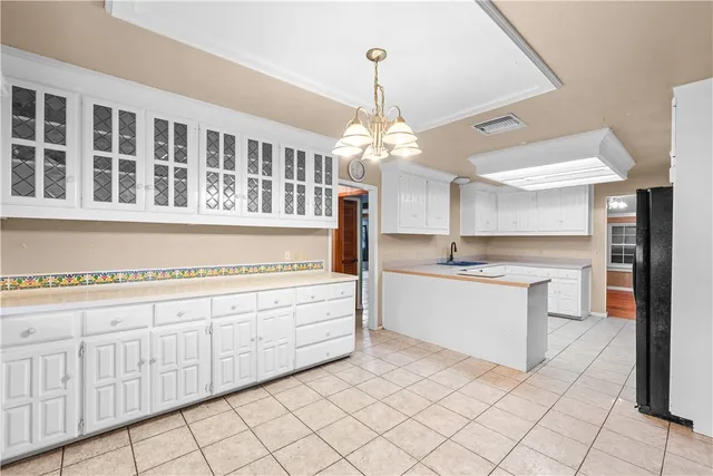 a large white kitchen with granite countertop a sink and white cabinets