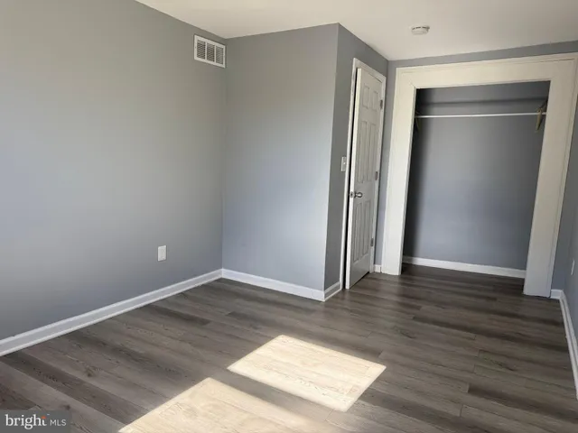 an empty room with wooden floor and closet