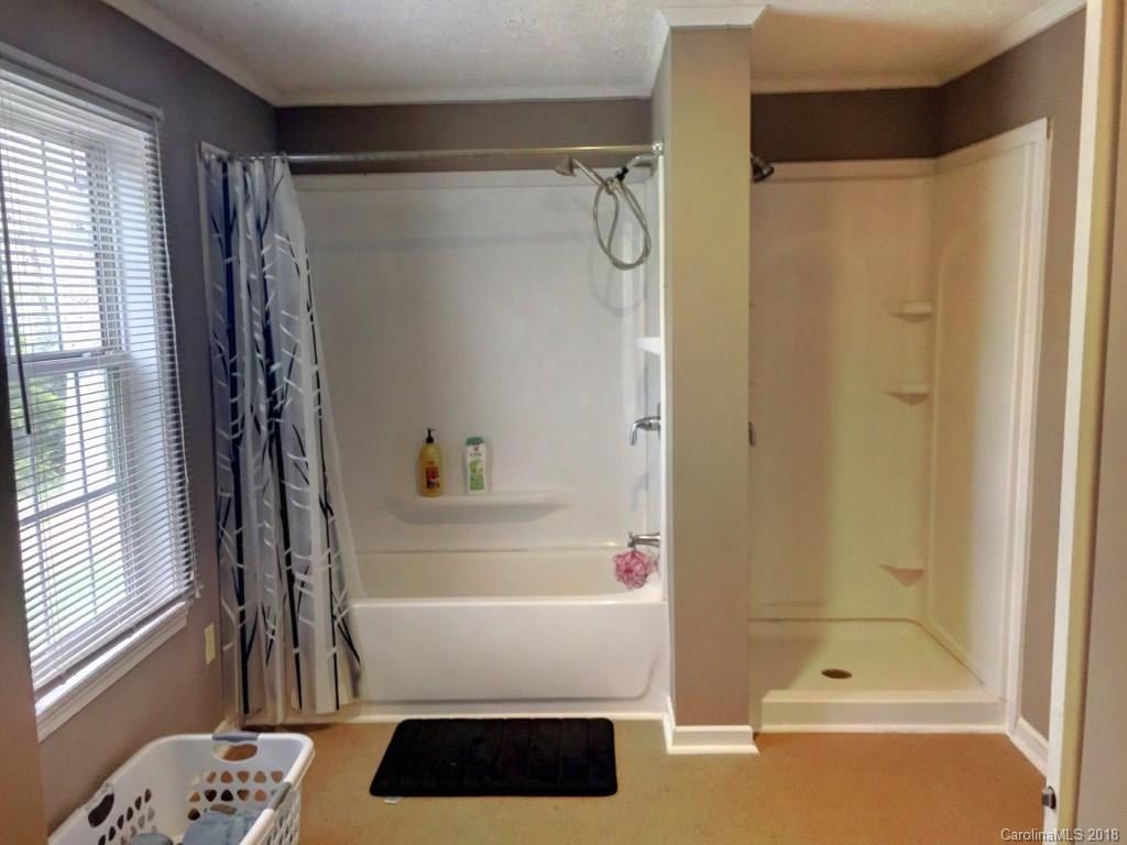 2915 Locust Grove Road Hendersonville, NC 28792 - Photo 18 of 30 a bathroom with a shower curtain and a window