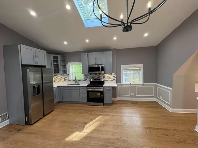a kitchen with granite countertop a refrigerator and a stove top oven