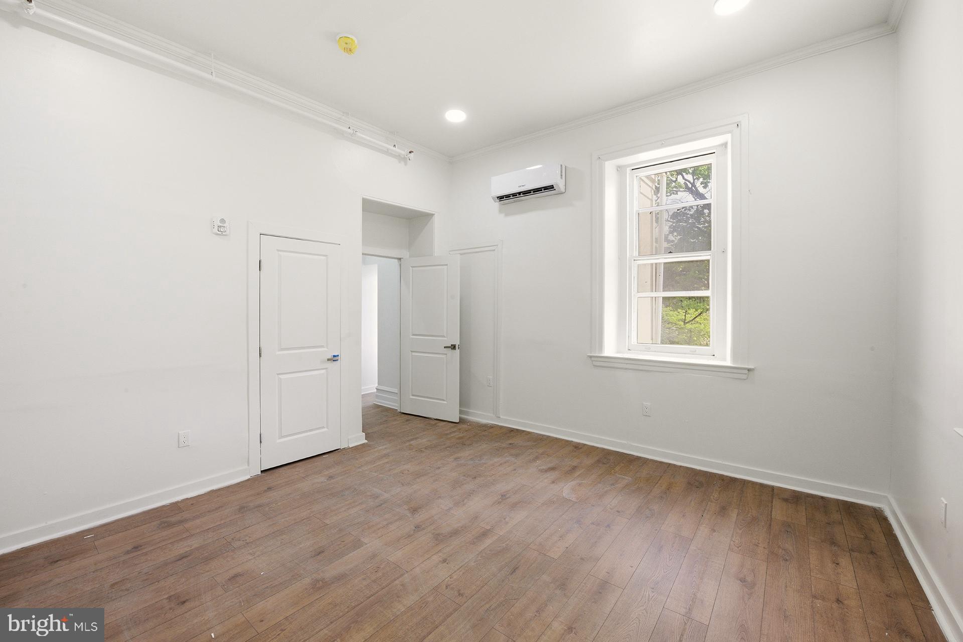 6012 Ridge Avenue, Unit 5 Philadelphia, PA 19128 - Photo 12 of 19 an empty room with wooden floor and windows