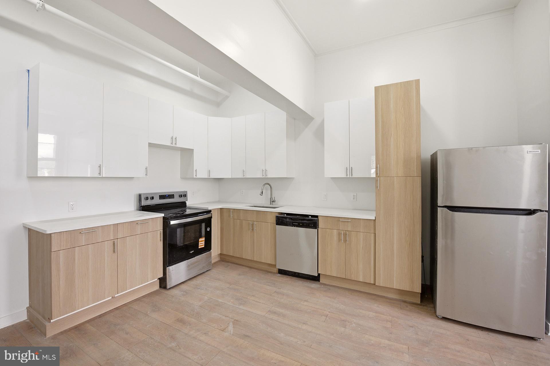 6012 Ridge Avenue, Unit 5 Philadelphia, PA 19128 - Photo 4 of 19 a kitchen with a refrigerator sink and white cabinets