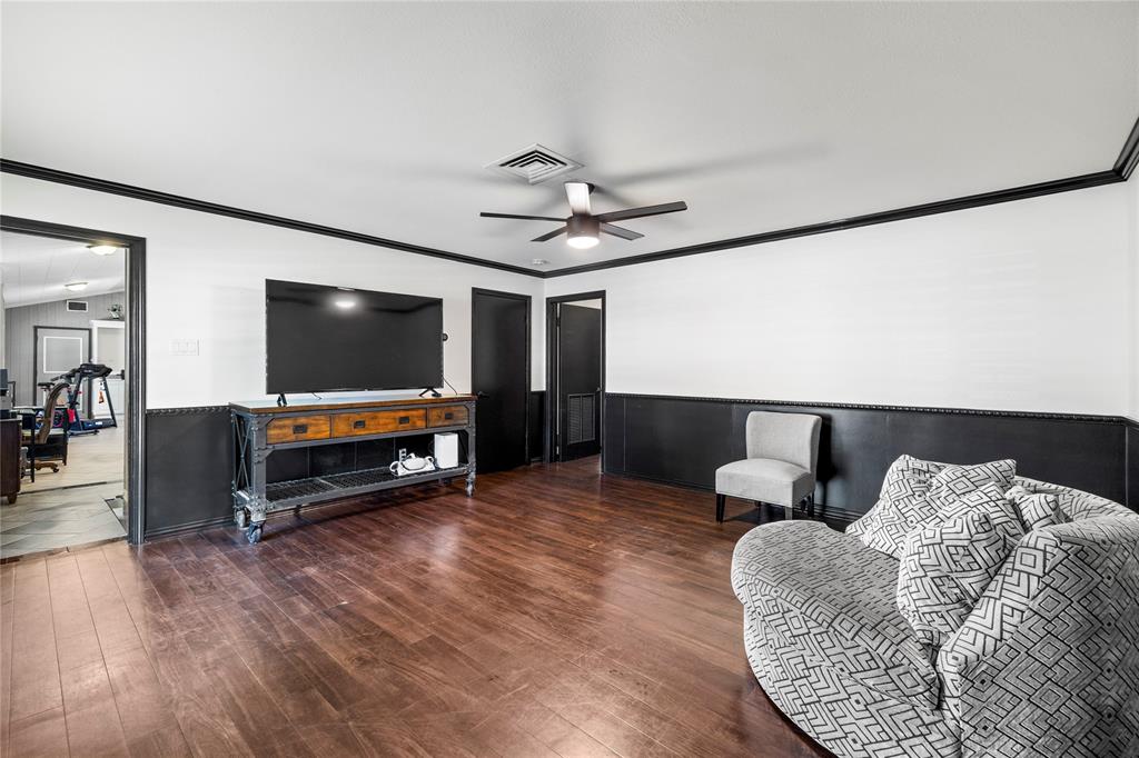 1300 Montclair Street Longview, TX 75601 - Photo 20 of 39 Living area featuring ornamental molding, wood finished floors, a wainscoted wall, and ceiling fan