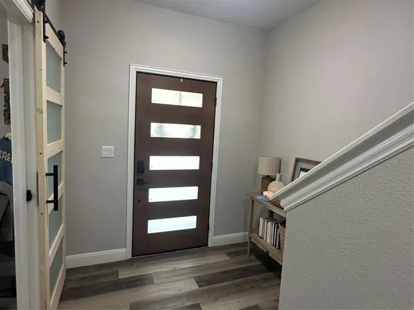 a view of an entryway with wooden floor and windows