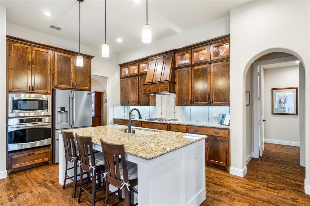 4111 Broadmoor Way Frisco, TX 75033 - Photo 11 of 38 a kitchen with stainless steel appliances kitchen island granite countertop a refrigerator and a stove top oven