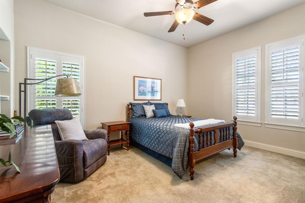 4111 Broadmoor Way Frisco, TX 75033 - Photo 22 of 38 a bed sitting in a bedroom next to a window with a chandelier and a couch