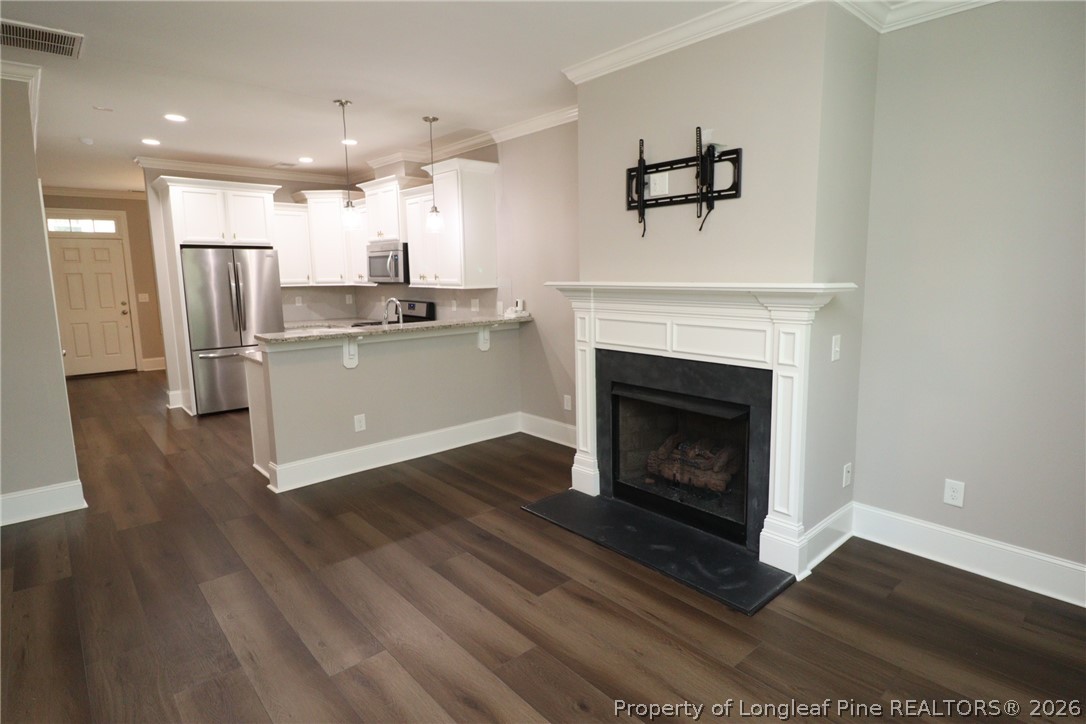 2824 Plumfield Place Raleigh, NC 27607 - Photo 15 of 33 a living room with stainless steel appliances wooden floor and a fireplace