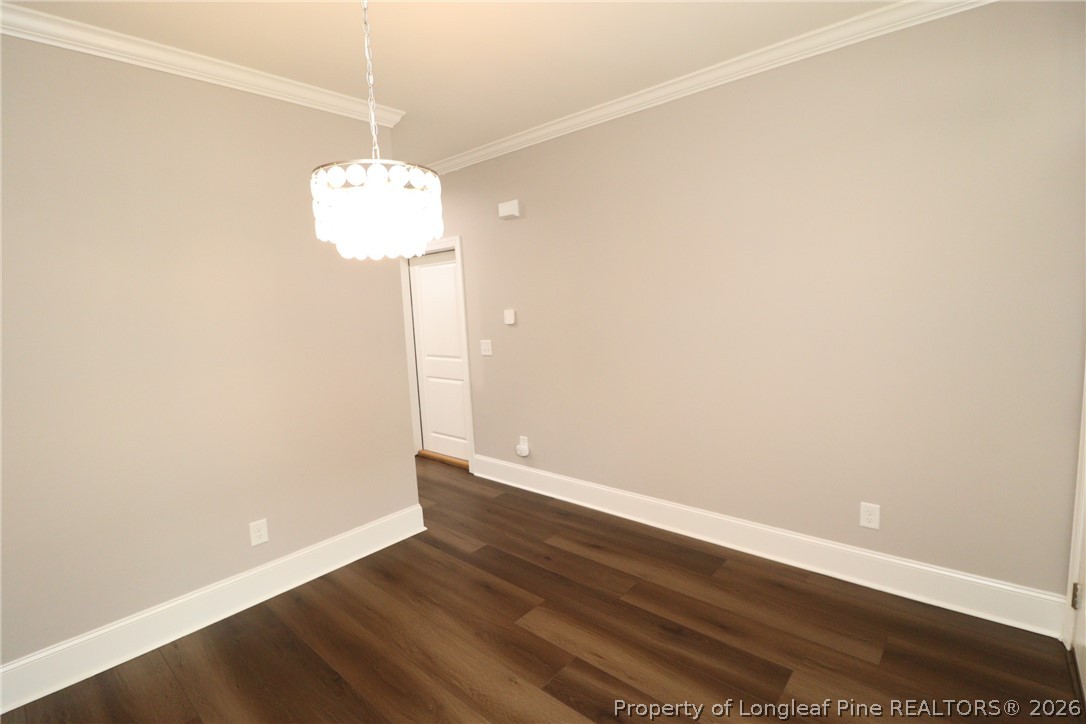 2824 Plumfield Place Raleigh, NC 27607 - Photo 4 of 33 a view of a room with wooden floor and chandelier