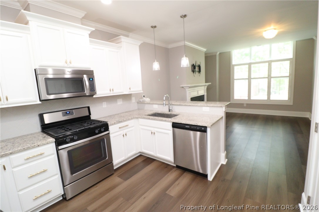 2824 Plumfield Place Raleigh, NC 27607 - Photo 6 of 33 a kitchen with granite countertop a stove a sink and a microwave