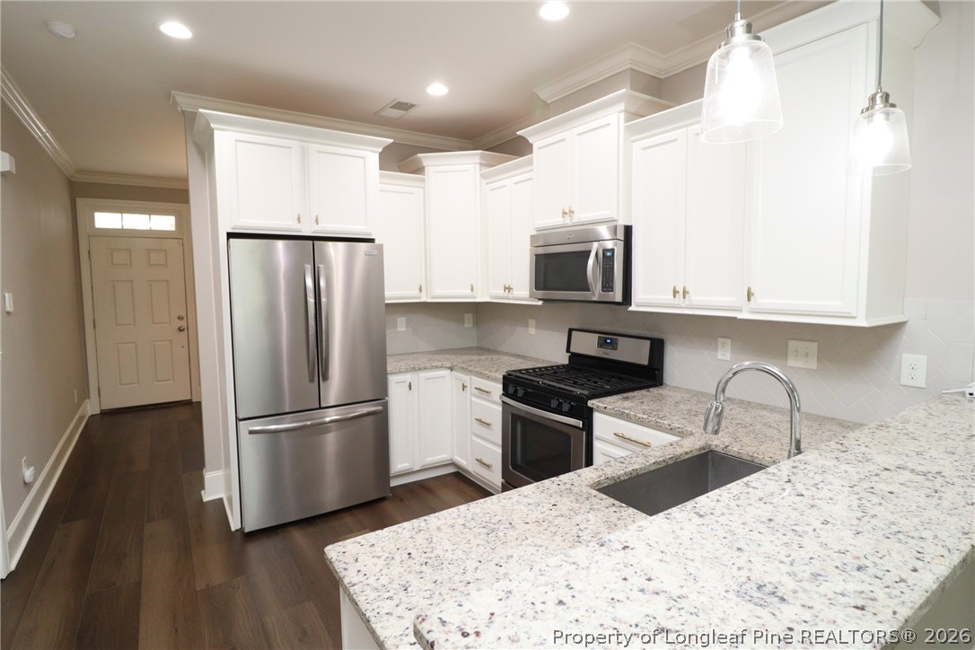 2824 Plumfield Place Raleigh, NC 27607 - Photo 7 of 33 a kitchen with granite countertop a refrigerator sink and microwave