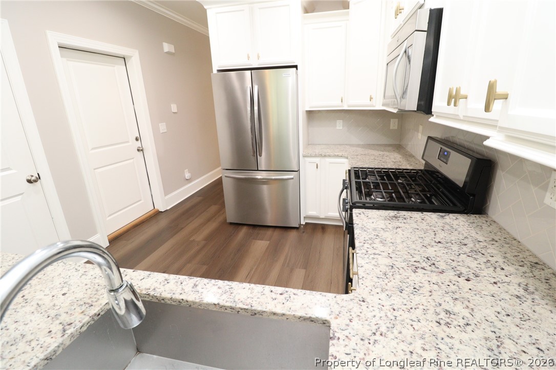 2824 Plumfield Place Raleigh, NC 27607 - Photo 9 of 33 a kitchen with a refrigerator and a stove top oven