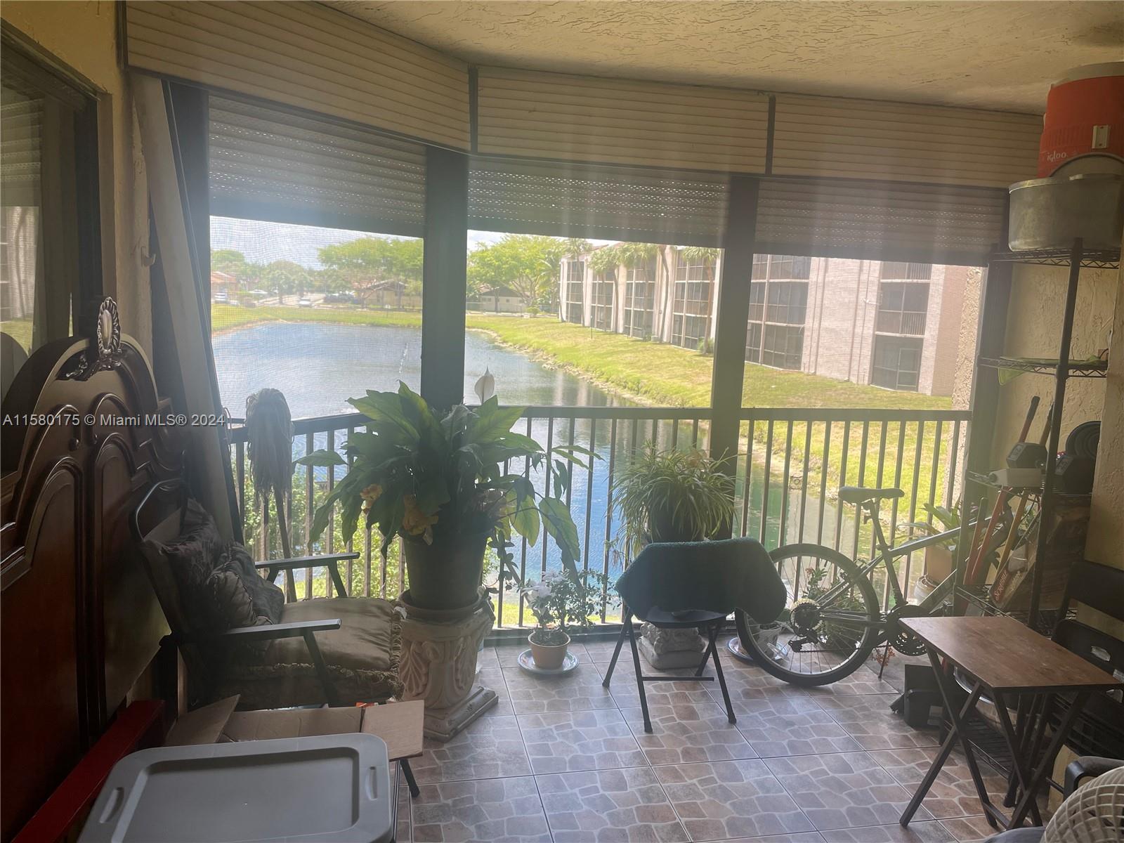 3252 Foxcroft Road, Unit 208 Miramar, FL 33025 - Photo 12 of 13 a living room filled with furniture and a floor to ceiling window