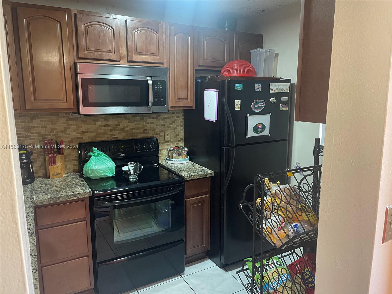 3252 Foxcroft Road, Unit 208 Miramar, FL 33025 - Photo 2 of 13 a kitchen with stainless steel appliances granite countertop a stove and a microwave
