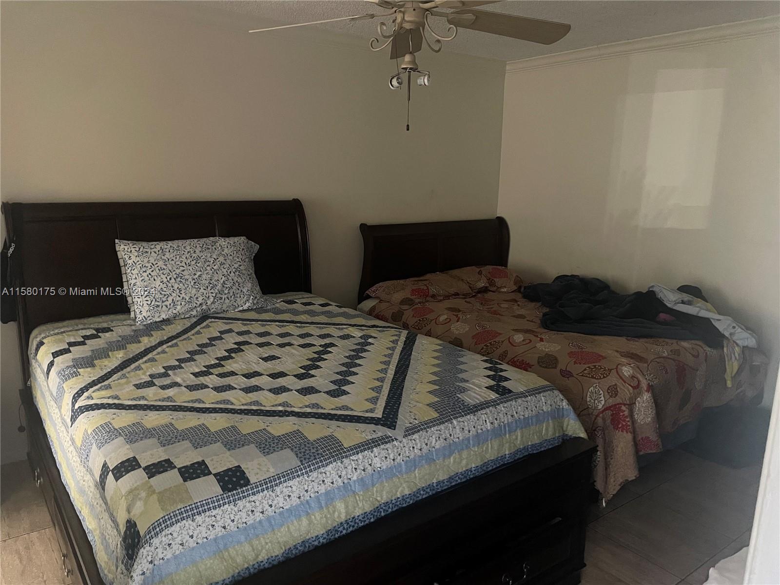 3252 Foxcroft Road, Unit 208 Miramar, FL 33025 - Photo 9 of 13 a bedroom with a bed and wooden floor