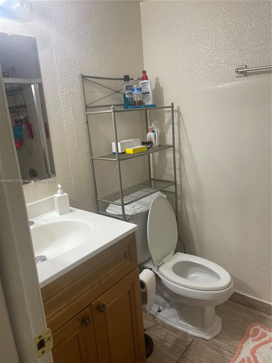 3252 Foxcroft Road, Unit 208 Miramar, FL 33025 - Photo 10 of 13 a bathroom with a sink a toilet and mirror
