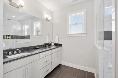 a bathroom with a granite countertop sink a toilet and a mirror