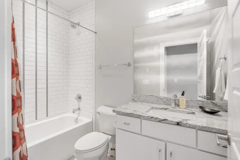a bathroom with a granite countertop sink toilet and shower