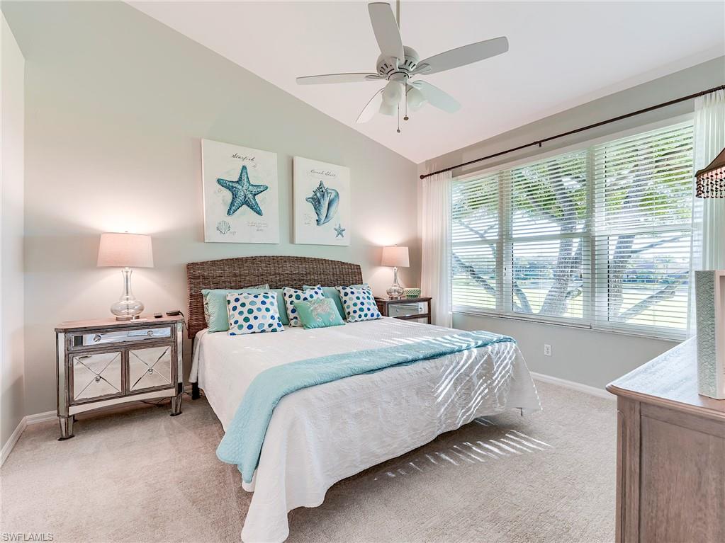 9010 Spring Run Boulevard, Unit 702 Estero, FL 34135 - Photo 14 of 35 a bedroom with a large bed and a chandelier