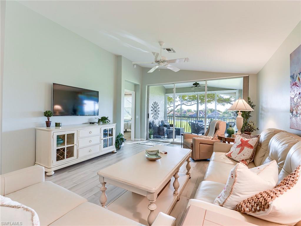 9010 Spring Run Boulevard, Unit 702 Estero, FL 34135 - Photo 4 of 35 a living room with furniture and a flat screen tv