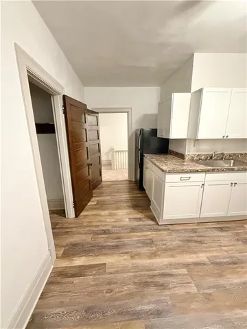 en empty room with a fireplace and ceiling fan