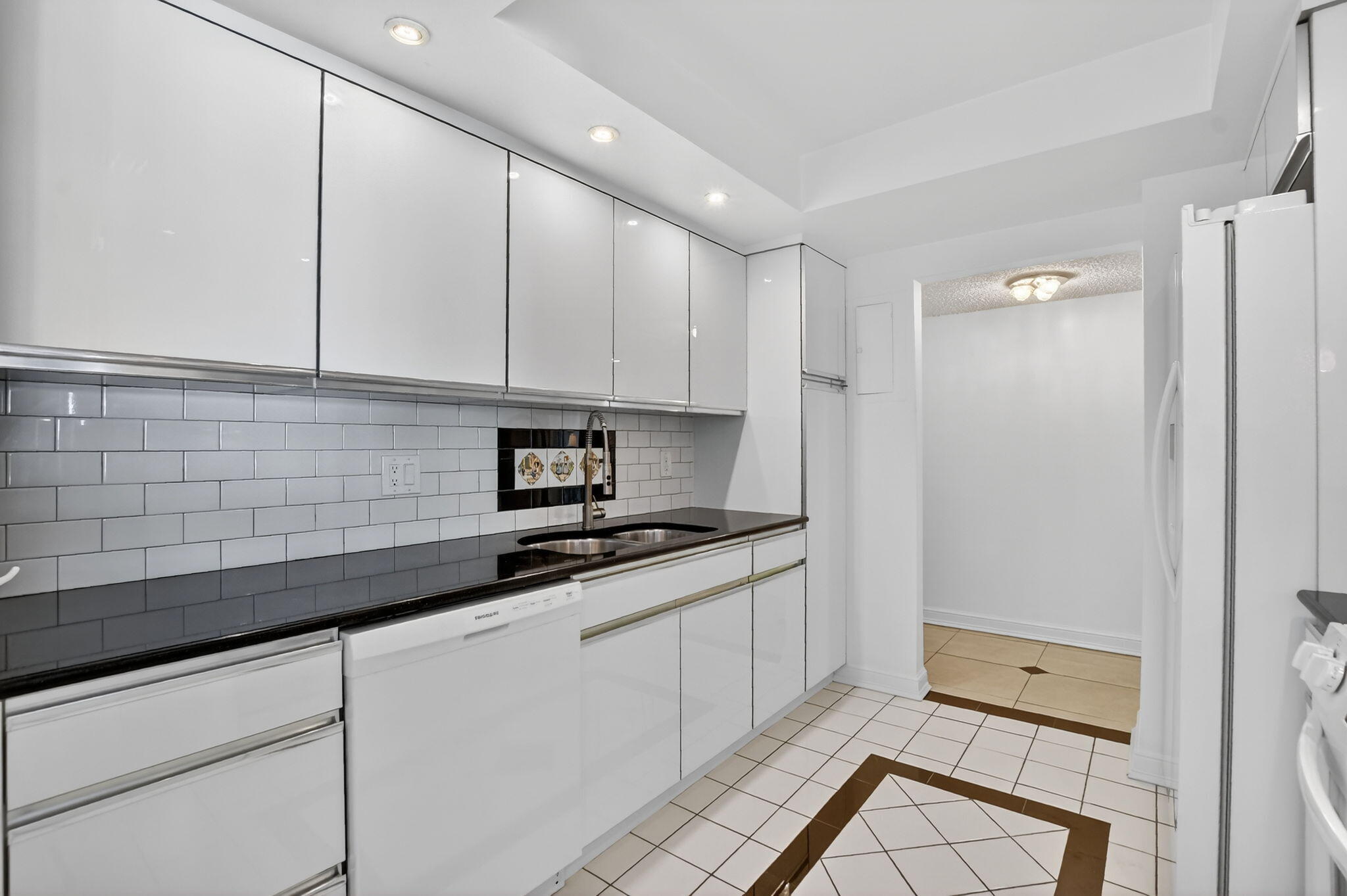 951 De Soto Road, Unit 427 Boca Raton, FL 33432 - Photo 16 of 50 a kitchen with granite countertop white cabinets and white appliances