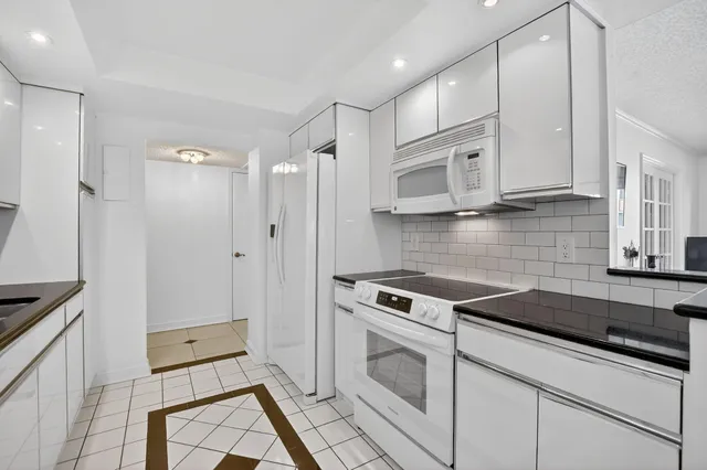 a kitchen with granite countertop a stove top oven cabinets a sink and a counter top space