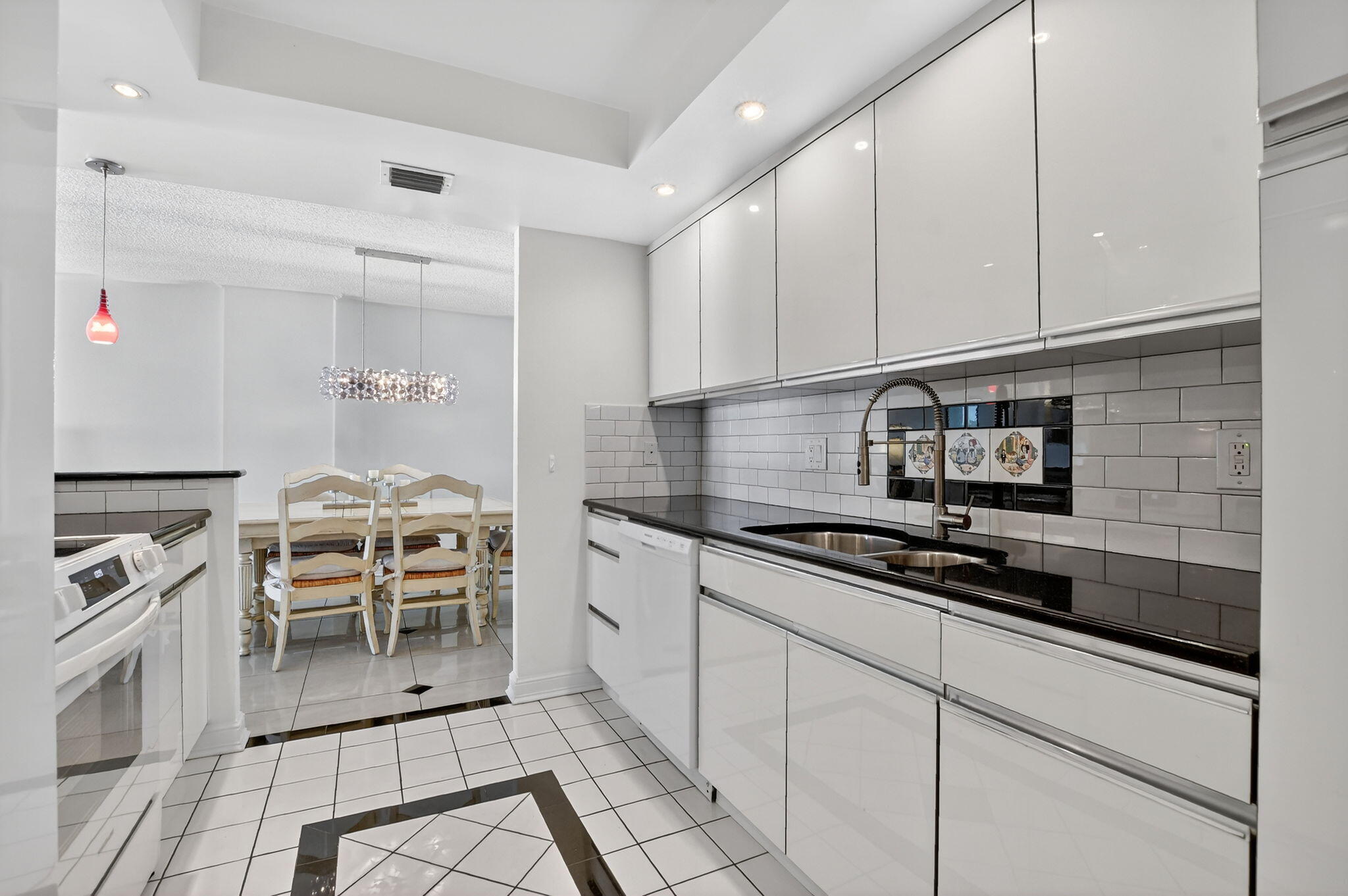 951 De Soto Road, Unit 427 Boca Raton, FL 33432 - Photo 19 of 50 a kitchen with granite countertop a stove top oven cabinets a sink and a counter top space