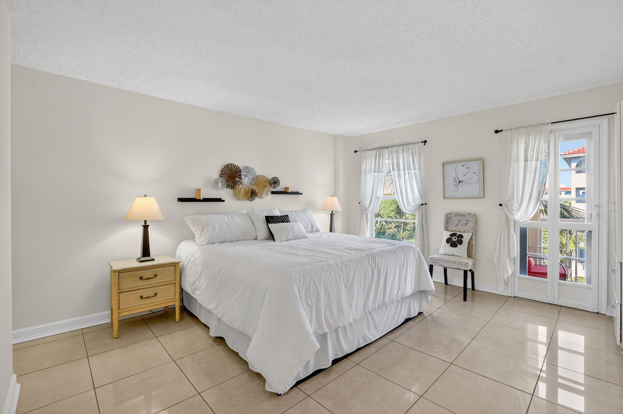 951 De Soto Road, Unit 427 Boca Raton, FL 33432 - Photo 24 of 50 a bedroom with a bed and a lamp on dresser