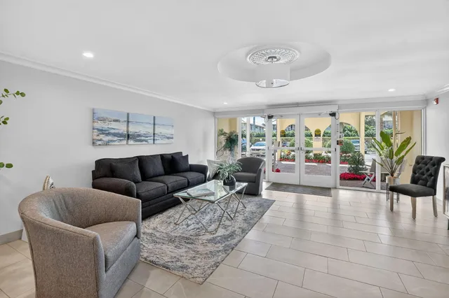 a living room with furniture a dining table and a chandelier