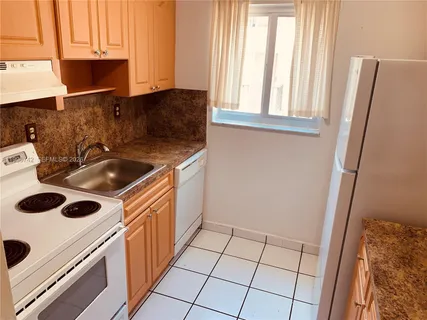 a kitchen with a sink and a stove next to a window