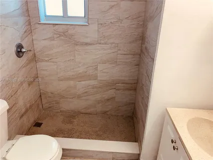 a bathroom with a toilet and a shower