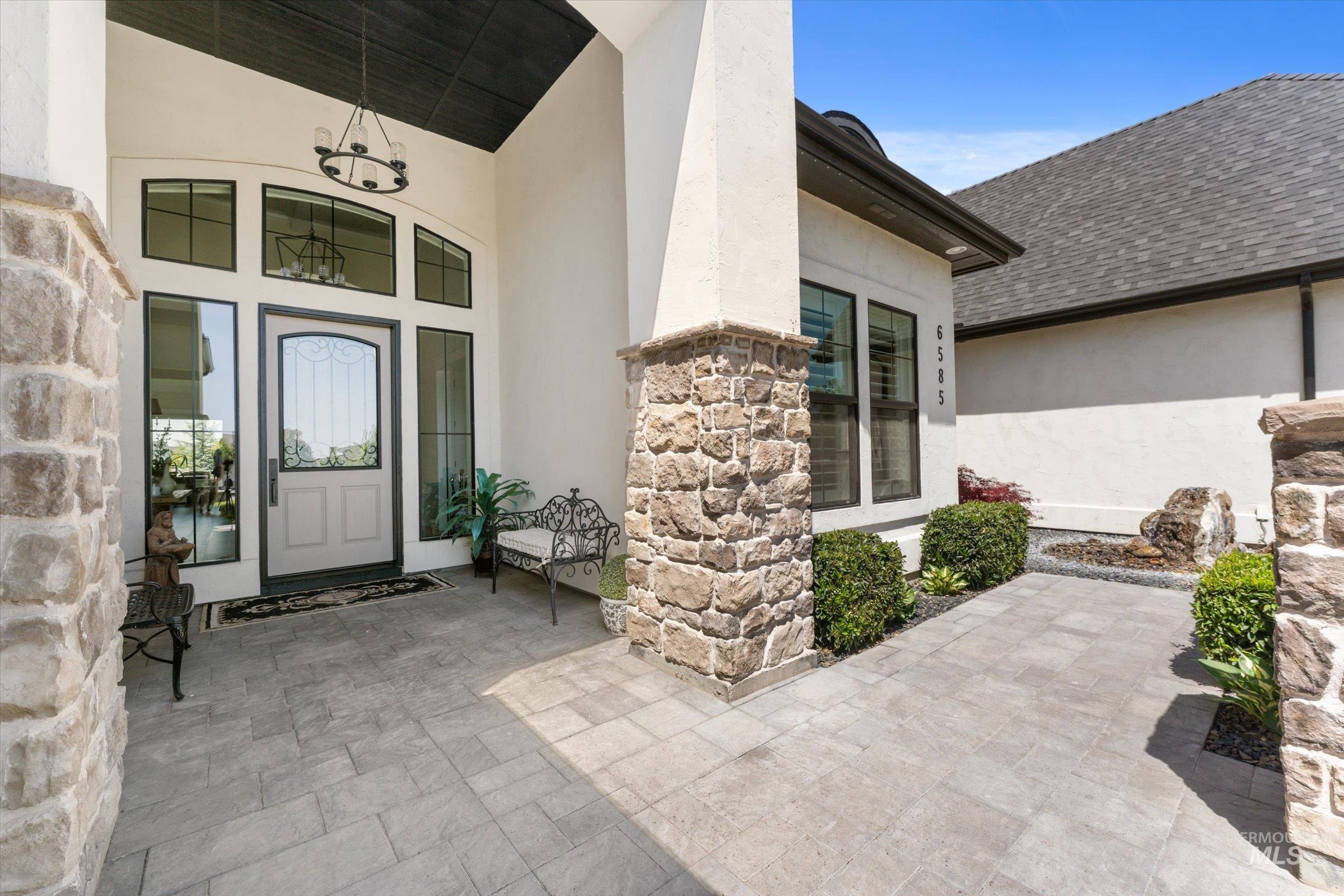 6585 South Pemberley Way Meridian, ID 83642 - Photo 6 of 43 Stone-clad column and facade accents complement a light-colored entry door with decorative glass inserts