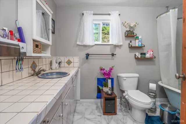 a bathroom with a sink a toilet and a window