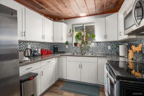 a kitchen with stainless steel appliances granite countertop a sink stove and cabinets