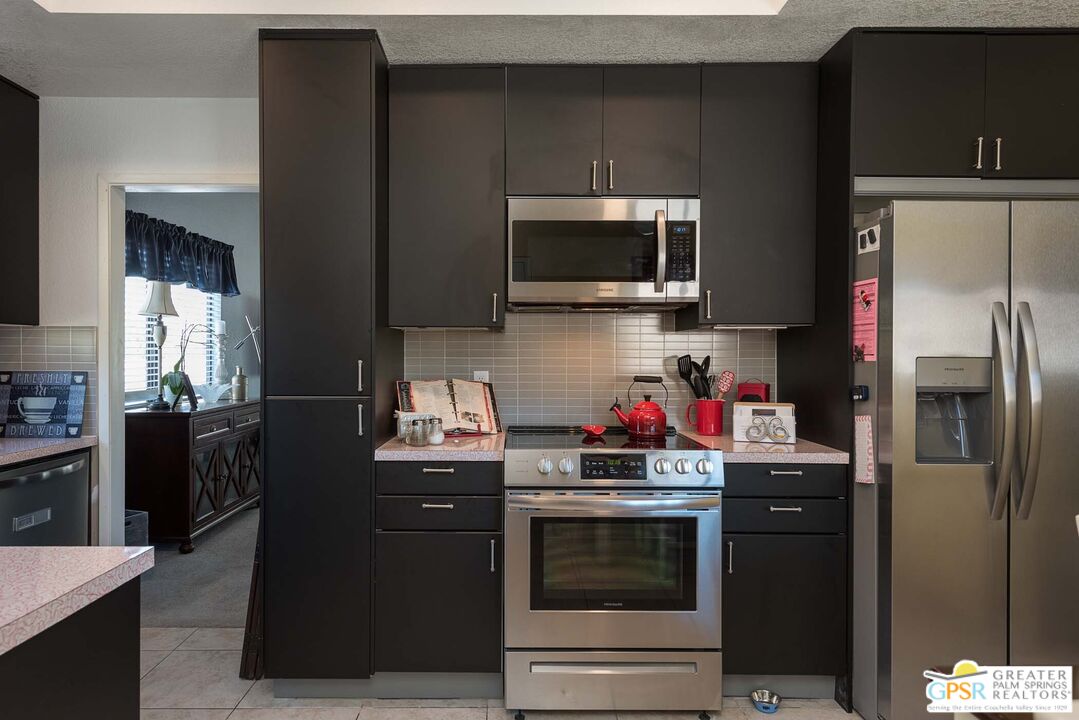 9760 Capiland Road Desert Hot Springs, CA 92240 - Photo 8 of 16 a kitchen with stainless steel appliances a stove microwave and refrigerator