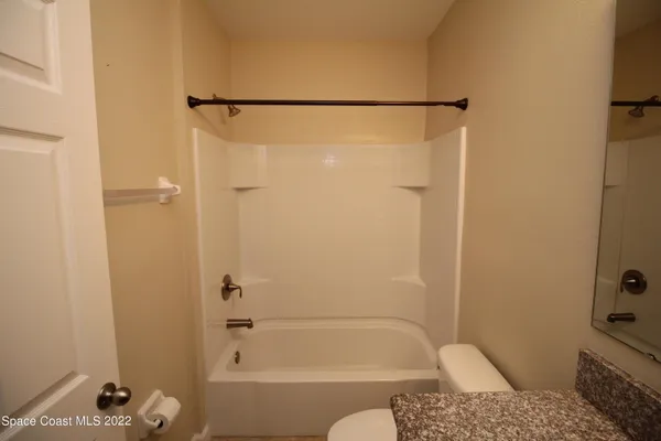 an empty room with a window and a ceiling fan