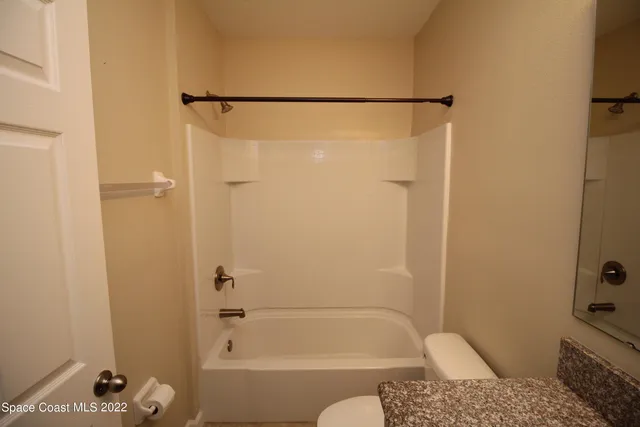 an empty room with a window and a ceiling fan