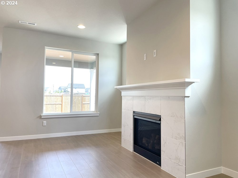 8728 North 3rd Street Ridgefield, WA 98642 - Photo 10 of 33 an empty room with wooden floor fireplace and windows