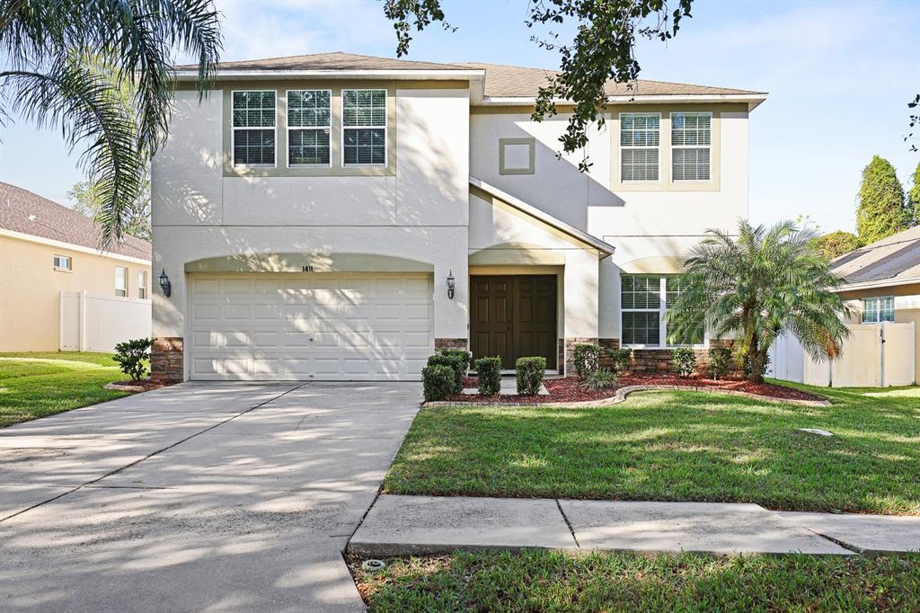 a front view of a house with a yard and garage