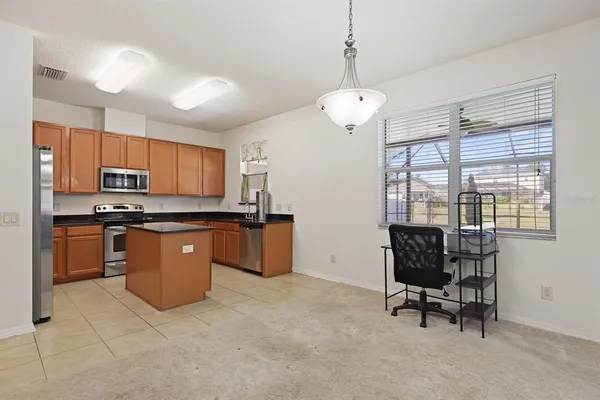 a view of kitchen with sink refrigerator and window