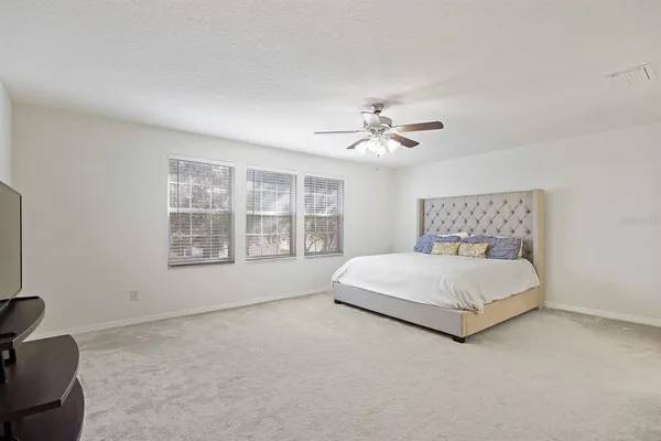 a spacious bedroom with a bed and window