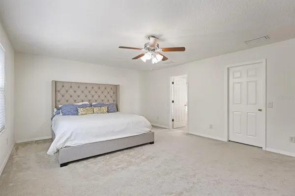 a bedroom with a bed and a ceiling fan